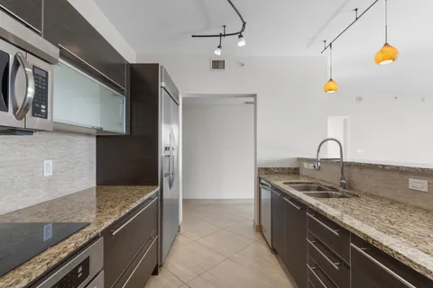 a kitchen with stainless steel appliances granite countertop a sink and a stove