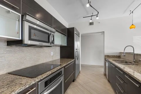 a kitchen with stainless steel appliances granite countertop a sink and stove top oven