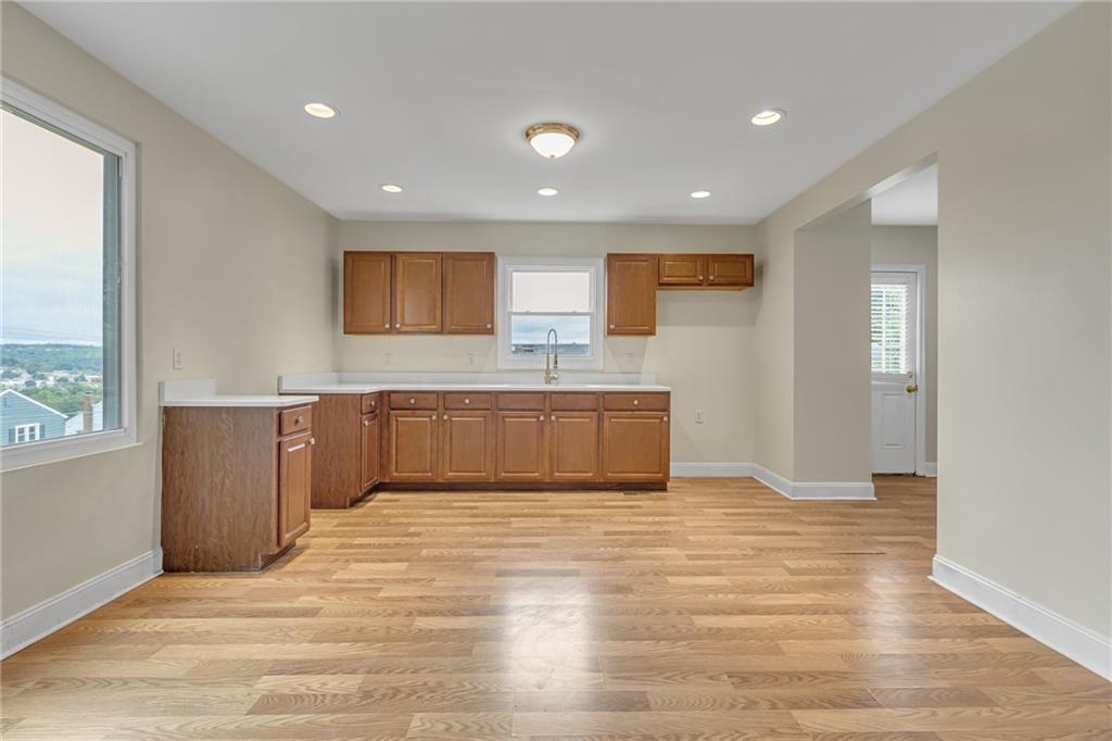 1736 Pierce Street Aliquippa, PA 15001 - Photo 6 of 19 a large white kitchen with wooden floors and white cabinets