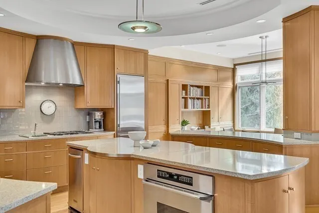 a kitchen with stainless steel appliances granite countertop a sink a stove and a refrigerator