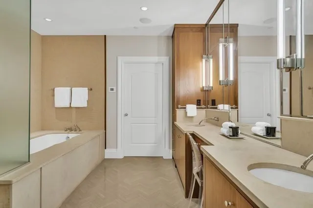 a bathroom with a tub sink and mirror