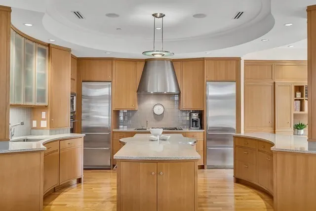 a kitchen with stainless steel appliances granite countertop a sink a stove and a refrigerator