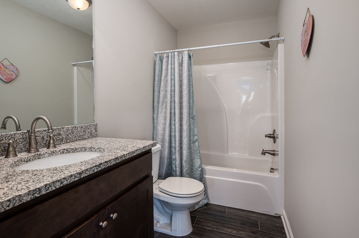 1382 Rural Hill Road, Unit 310 Antioch, TN 37013 - Photo 11 of 12 a bathroom with a granite countertop sink toilet and shower