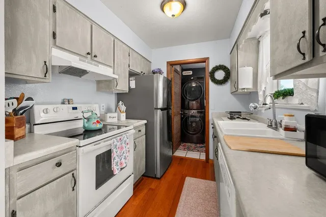 a kitchen with stainless steel appliances granite countertop a stove a sink and a refrigerator