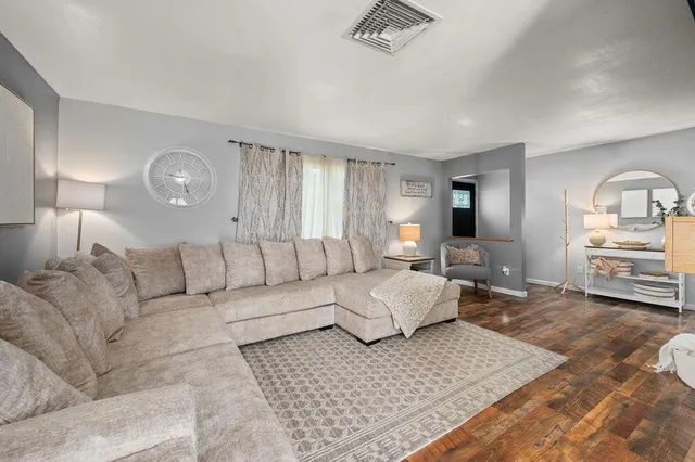 a living room with furniture and a wooden floor