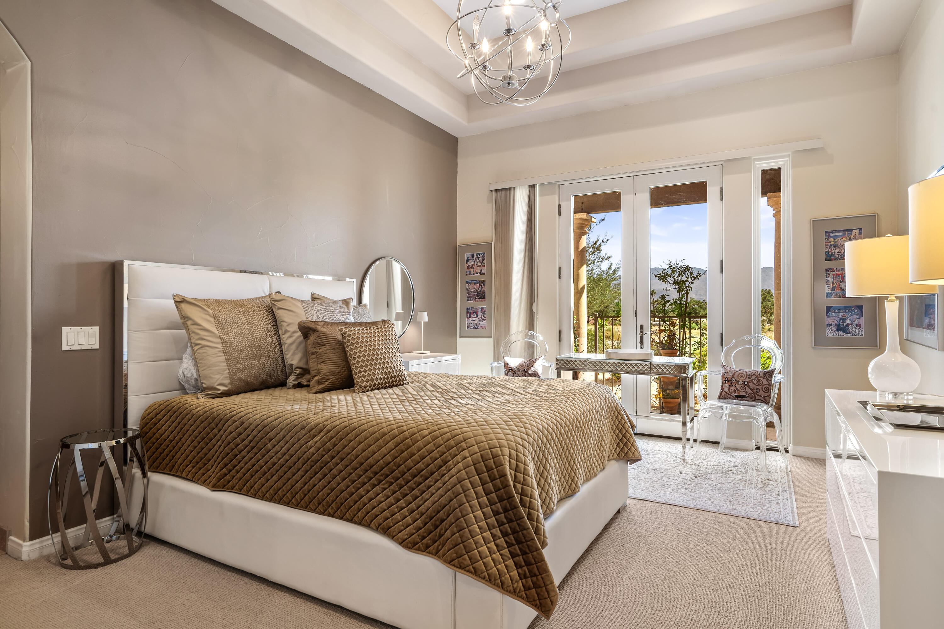 106 Piazza Perrone Palm Desert, CA 92260 - Photo 28 of 68 a bedroom with a large bed and a chandelier