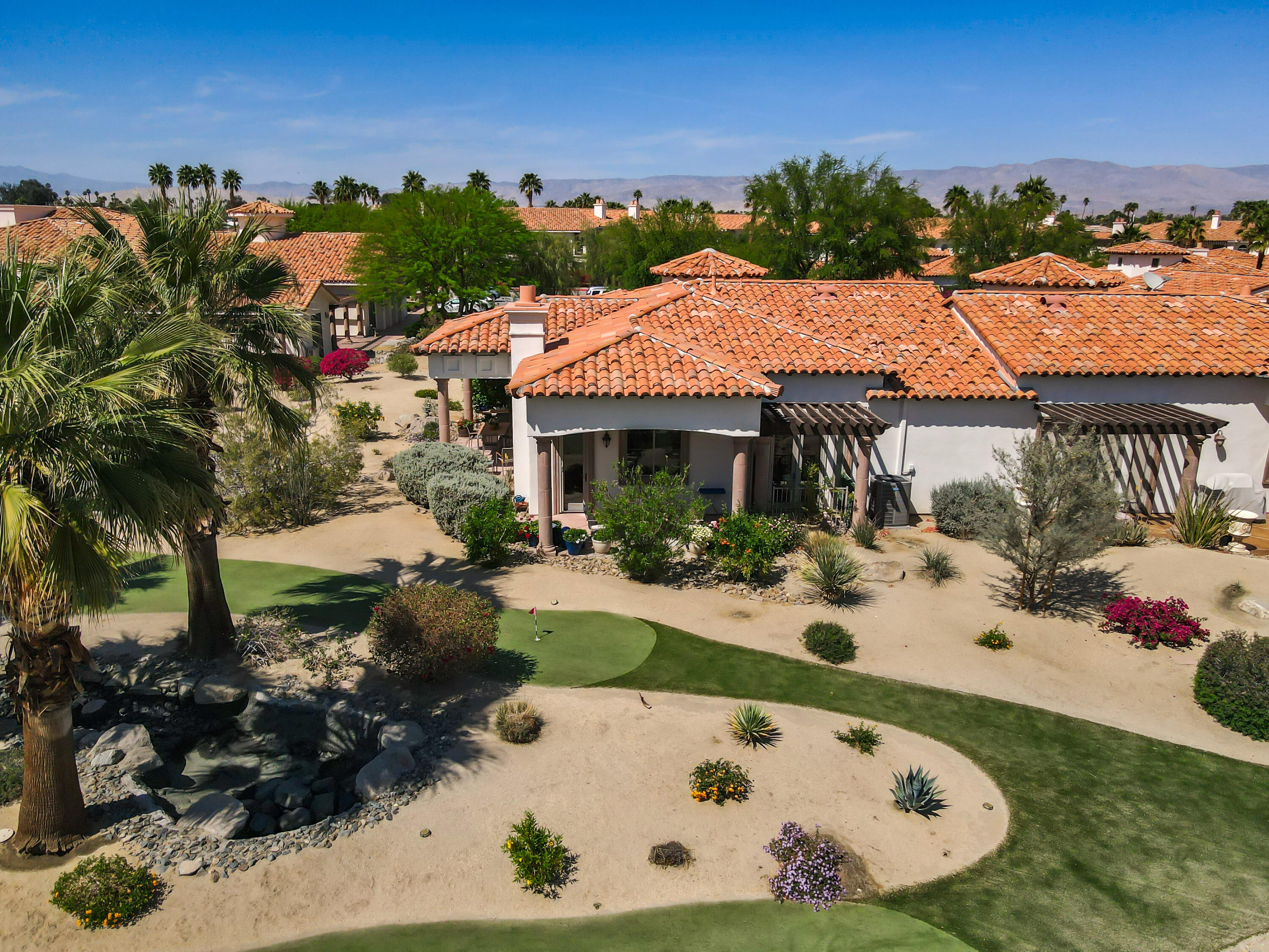 106 Piazza Perrone Palm Desert, CA 92260 - Photo 63 of 68 a view of a white house with a yard patio and fire pit
