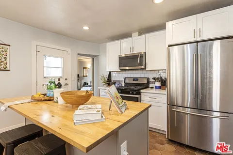 a kitchen with kitchen island a refrigerator stove microwave and cabinets