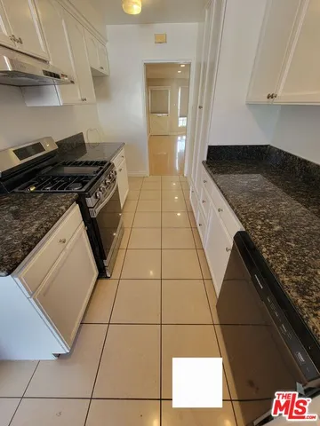 a kitchen with granite countertop a stove and a cabinets