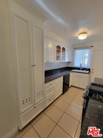 a kitchen with granite countertop white cabinets and white appliances