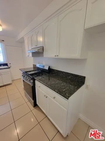a kitchen with stainless steel appliances granite countertop a sink stove and cabinets