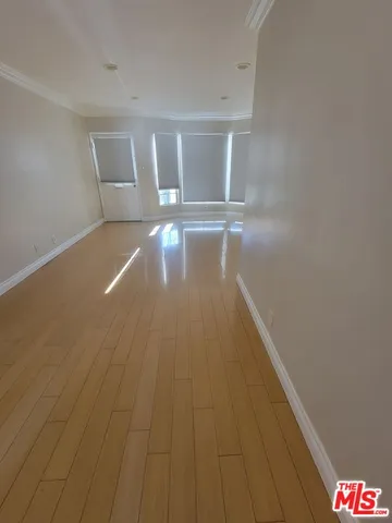 a view of empty room with wooden floor