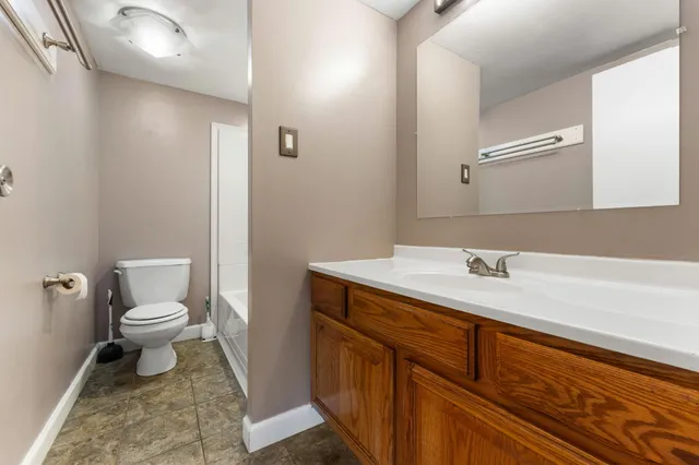 a bathroom with a toilet sink and mirror
