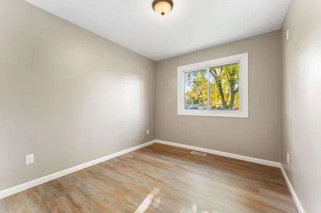 a view of room with window and wooden floor