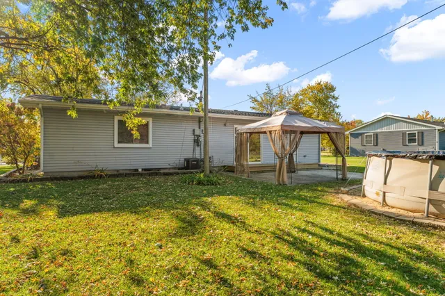 a view of a yard with a house and a large tree