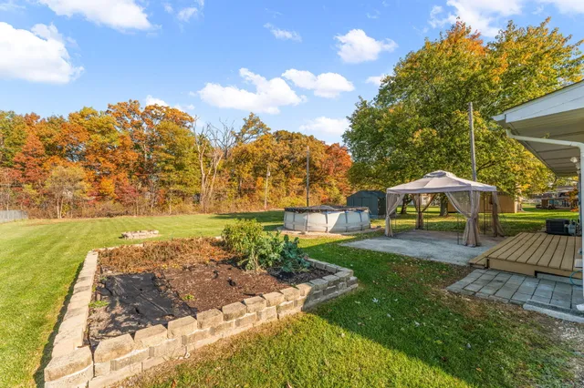 a view of a house with a yard and sitting area