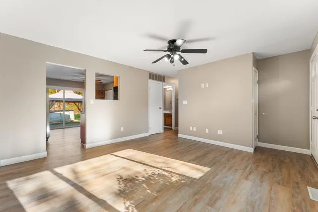 a view of a big room with wooden floor and a ceiling fan