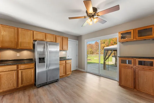 a kitchen with stainless steel appliances granite countertop a refrigerator a stove and a wooden floors
