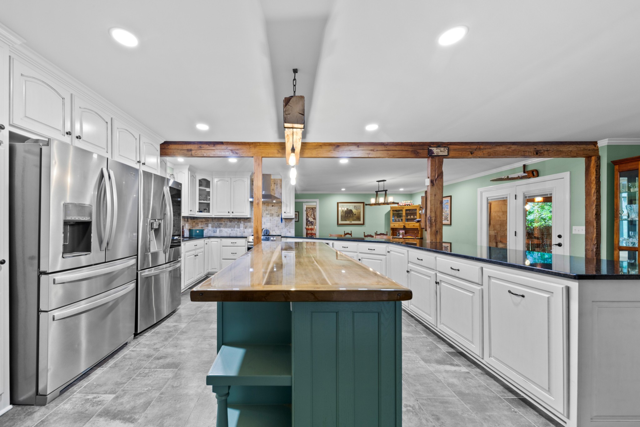 a kitchen with stainless steel appliances kitchen island granite countertop a refrigerator and a stove top oven
