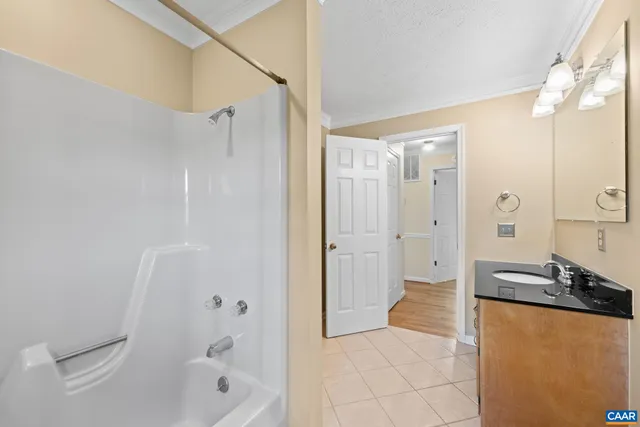 a bathroom with a granite countertop sink a mirror a bathtub and shower