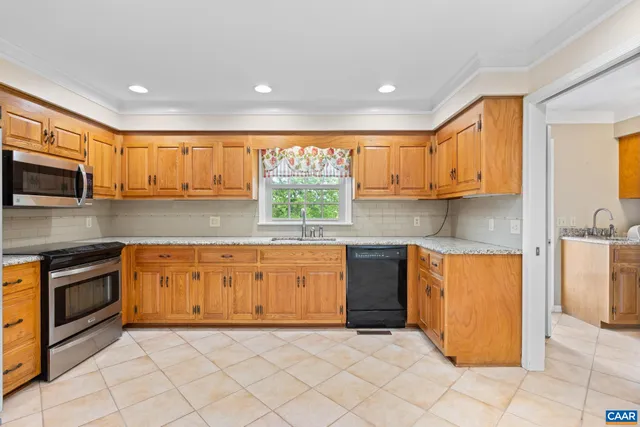a kitchen with stainless steel appliances granite countertop a stove top oven a sink a counter space and cabinets
