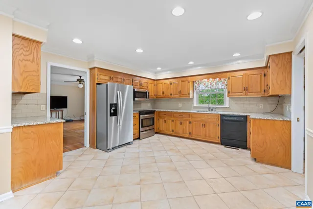 a large kitchen with stainless steel appliances a refrigerator and a stove top oven