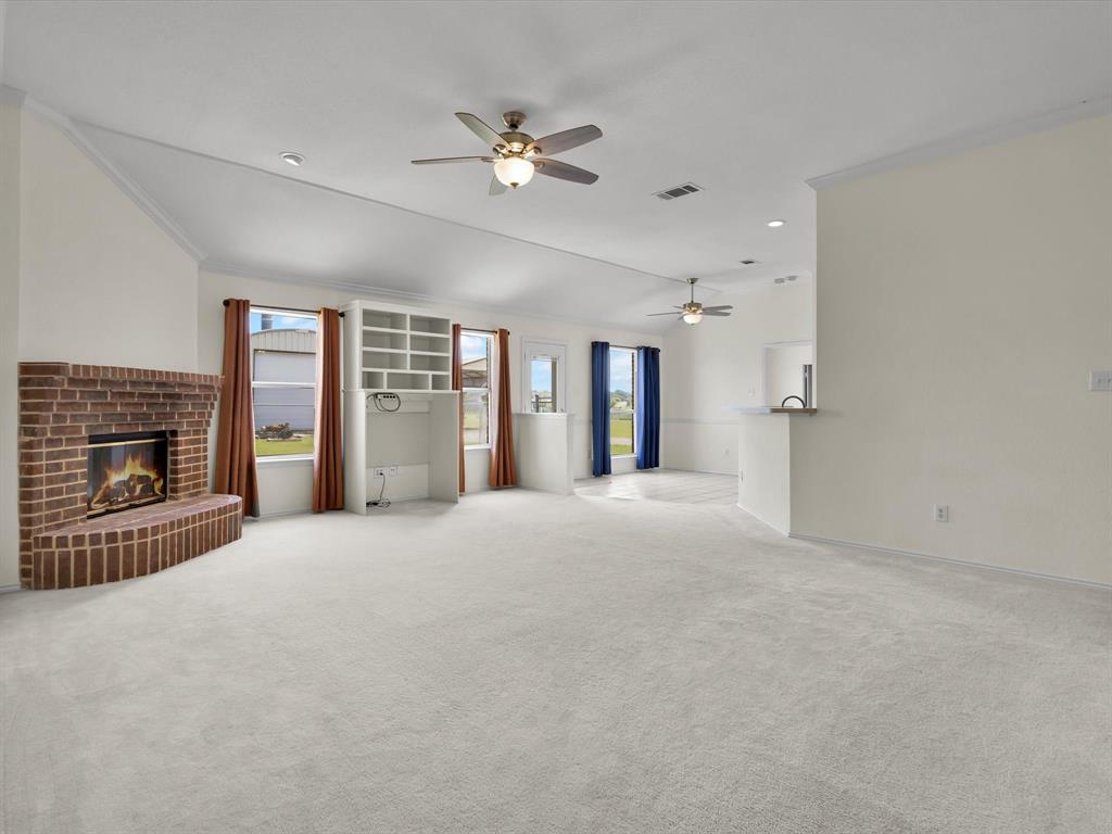 10832 Sky Ridge Court Haslet, TX 76052 - Photo 12 of 40 a view of an empty room with a fireplace and chandelier fan