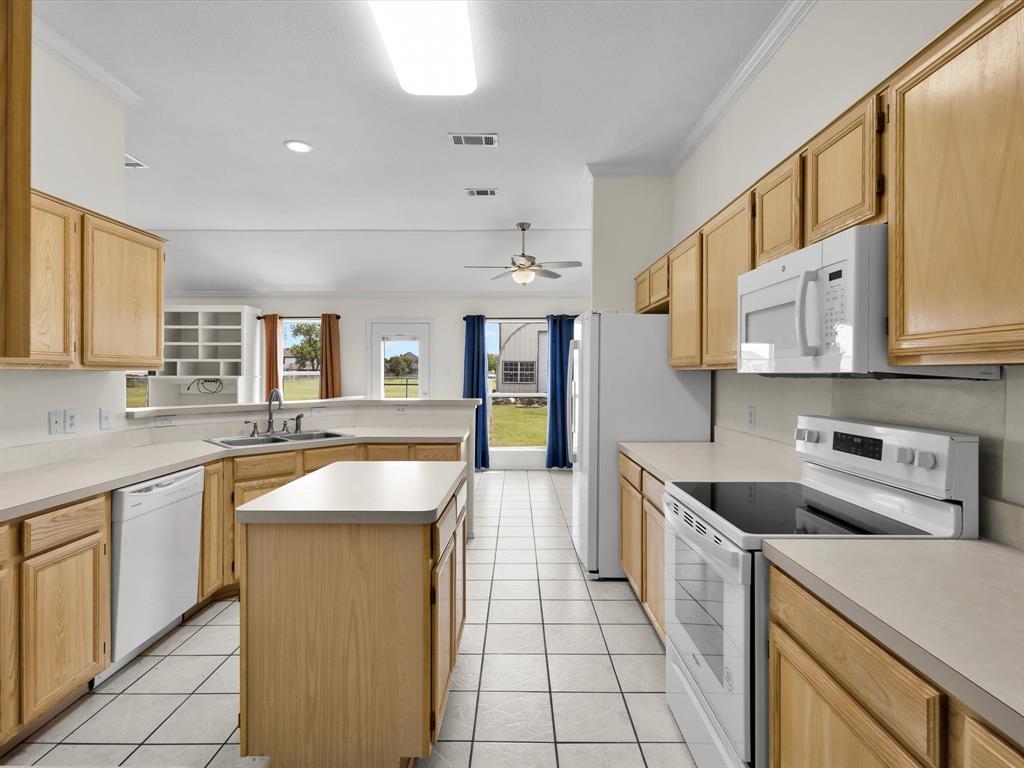 10832 Sky Ridge Court Haslet, TX 76052 - Photo 19 of 40 a kitchen with stainless steel appliances granite countertop a sink and a stove