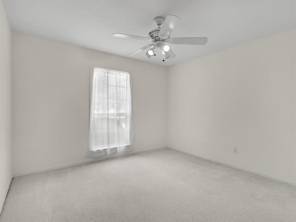 10832 Sky Ridge Court Haslet, TX 76052 - Photo 32 of 40 an empty room with a chandelier fan and windows
