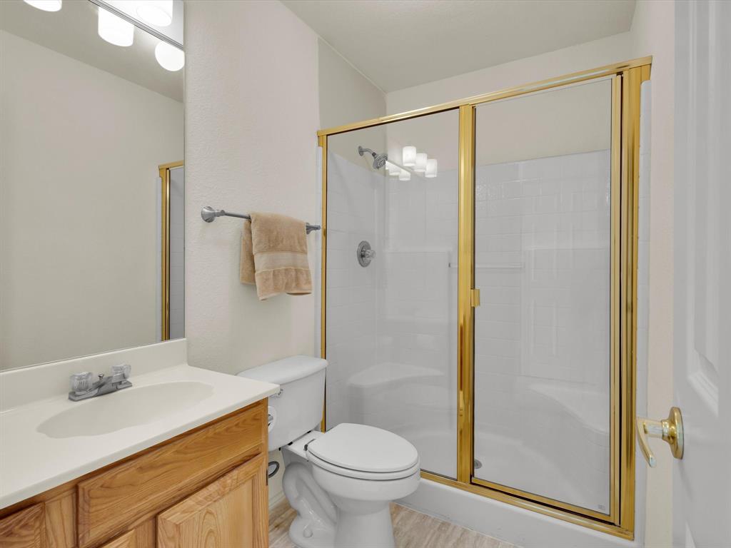 10832 Sky Ridge Court Haslet, TX 76052 - Photo 34 of 40 a bathroom with a granite countertop sink toilet and shower