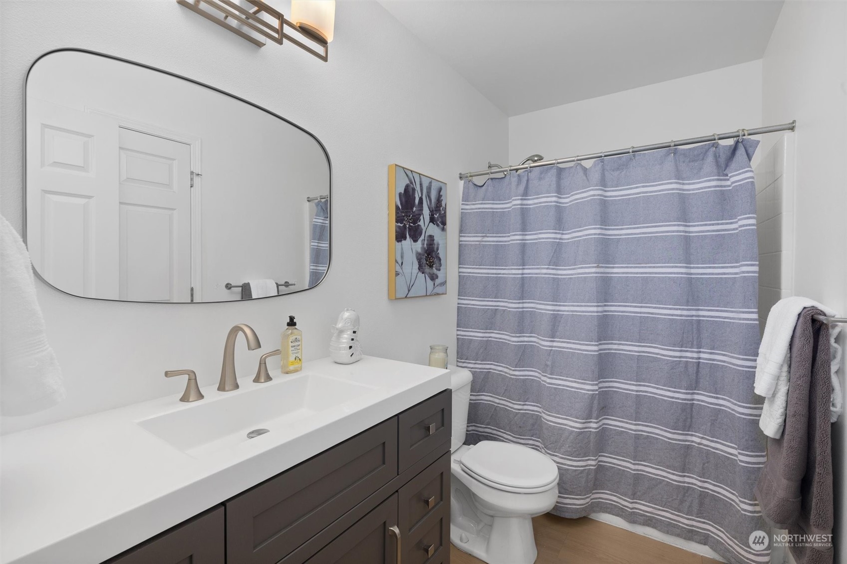 513 211th Place Southeast Bothell, WA 98021 - Photo 21 of 39 a bathroom with a sink a toilet a mirror and shower curtain