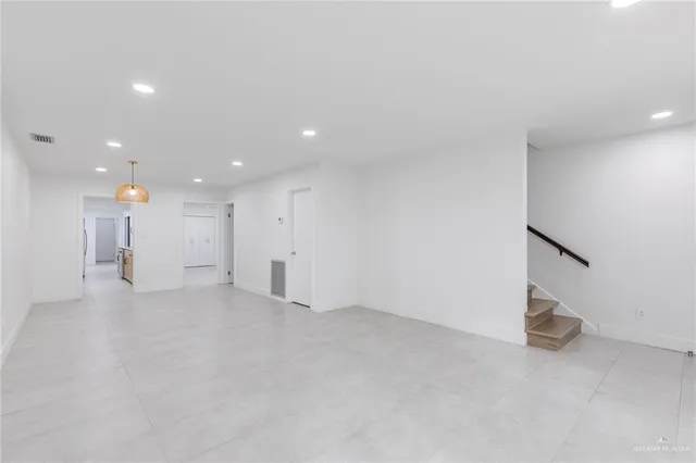 an empty room with windows and cabinet