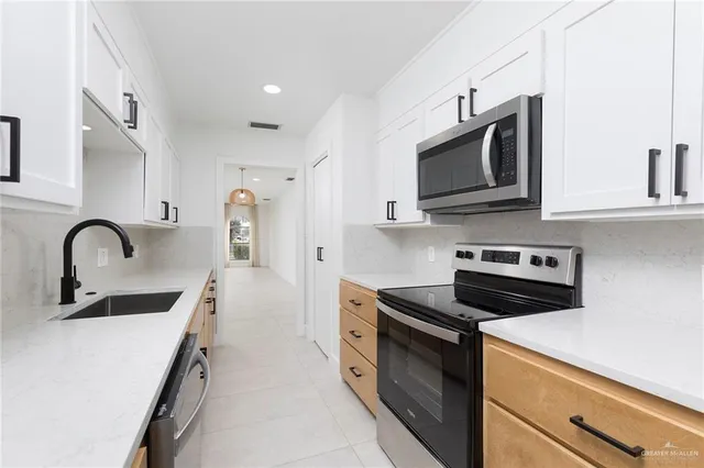 a view of an empty room with wooden floor and windows