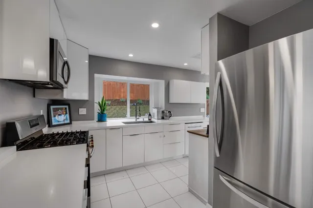 a kitchen with stainless steel appliances a refrigerator sink and microwave