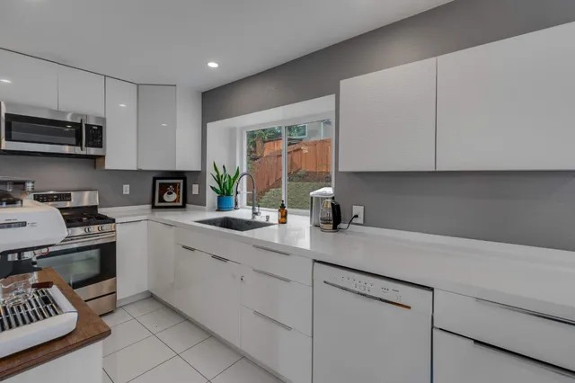 a kitchen with stainless steel appliances granite countertop a sink and a stove