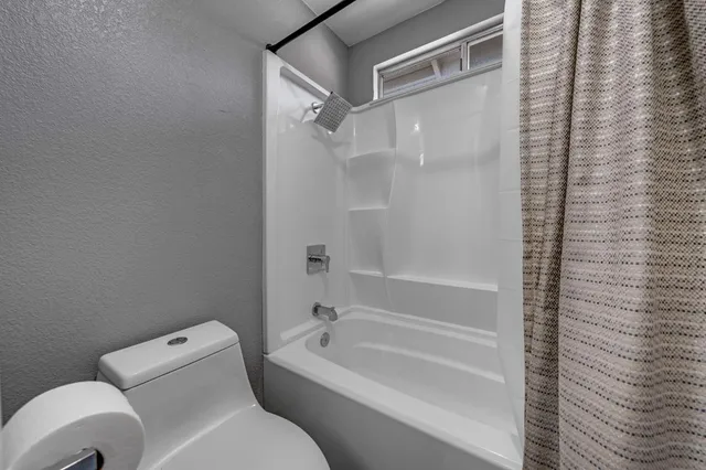 a bathroom with a toilet and a bathtub