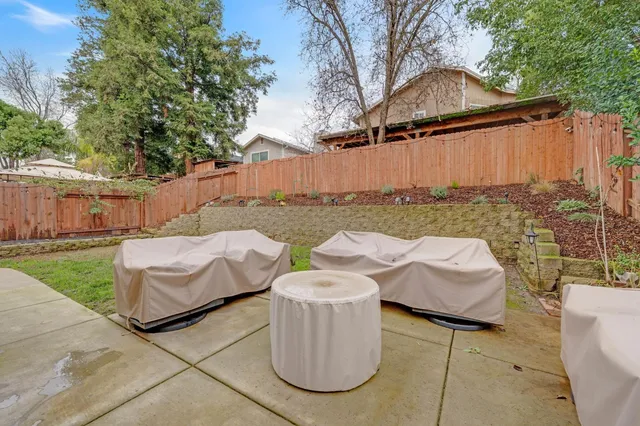 a backyard of a house with table and chairs