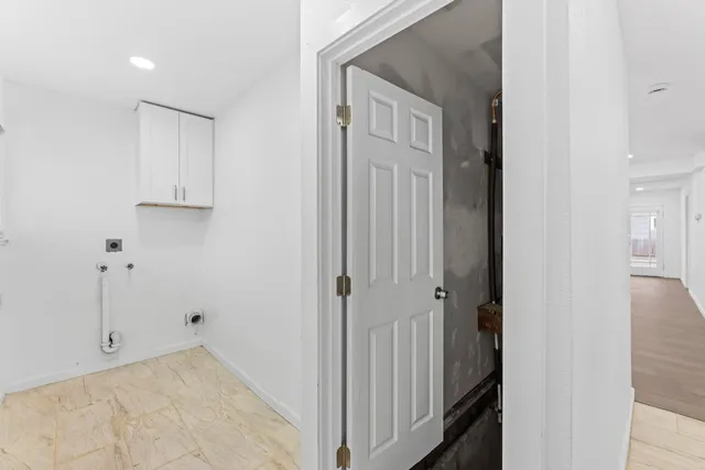 a view of hallway with window and wooden floor