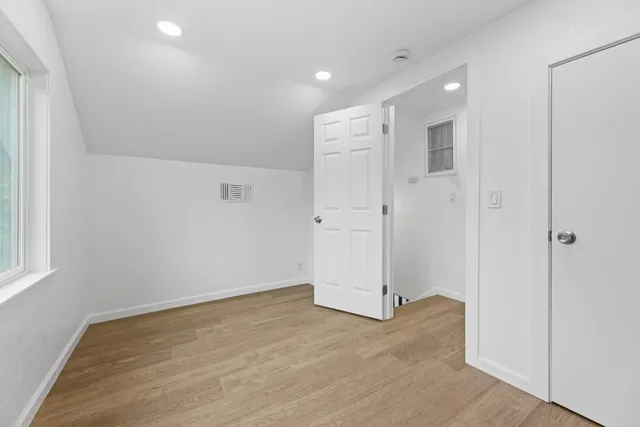 a view of empty room with wooden floor