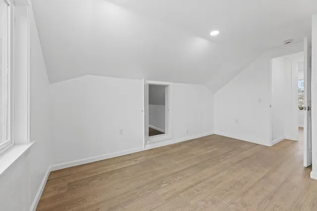 a view of a kitchen with white cabinets and a window