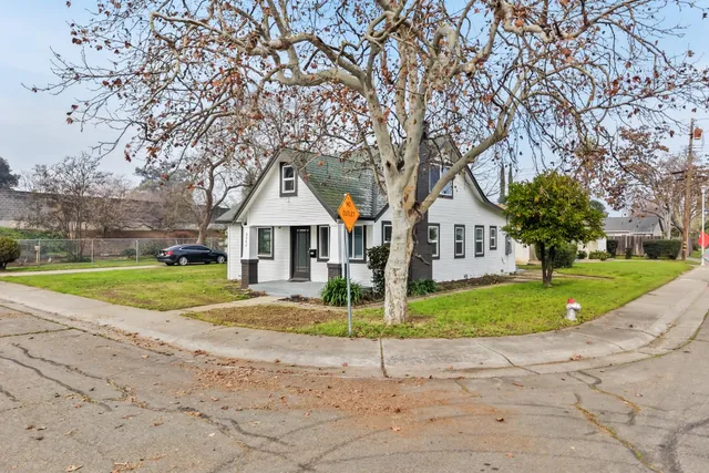 a view of a house next to a road and yard