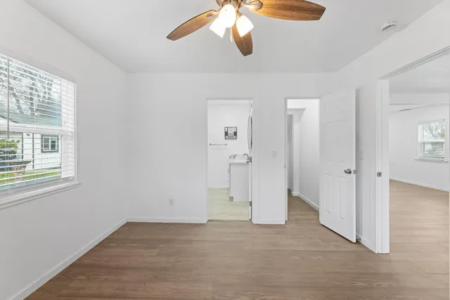a view of an empty room with chandelier fan and fire place