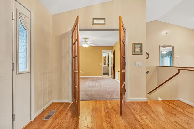 a view of a hallway with wooden floor and staircase