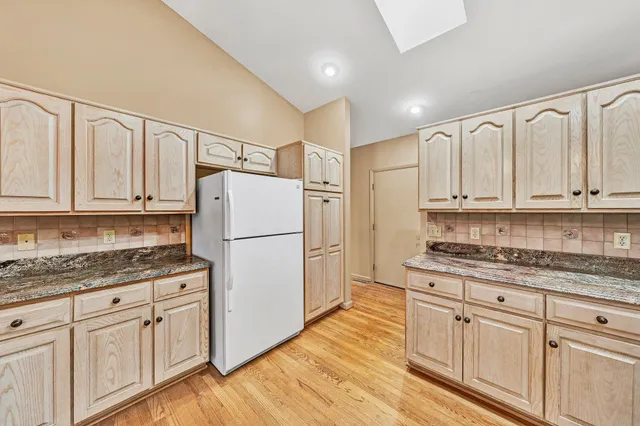 a kitchen with granite countertop white cabinets white appliances and sink