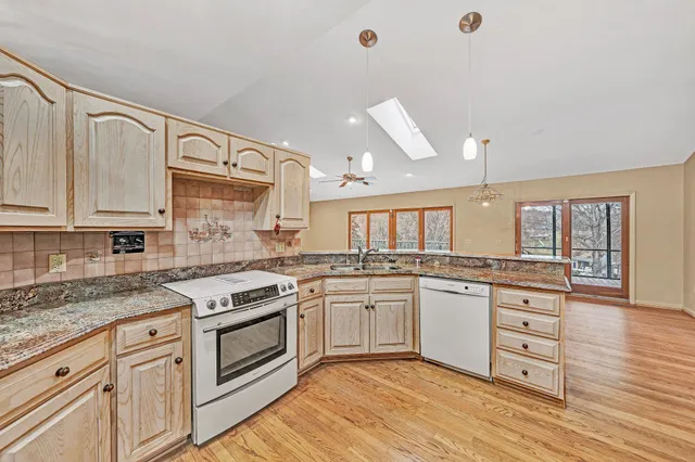 a kitchen with granite countertop white cabinets and white appliances