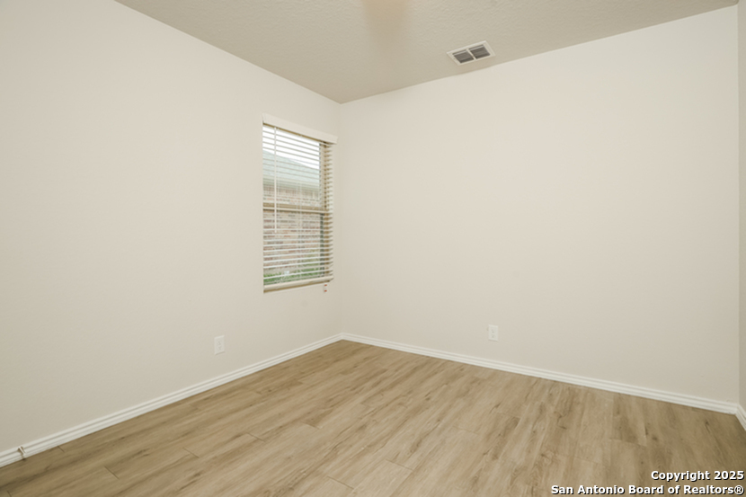 5227 Blue Ranch San Antonio, TX 78222 - Photo 12 of 17 a view of an empty room with wooden floor and a window