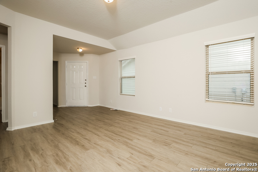 5227 Blue Ranch San Antonio, TX 78222 - Photo 6 of 17 an empty room with wooden floor and windows