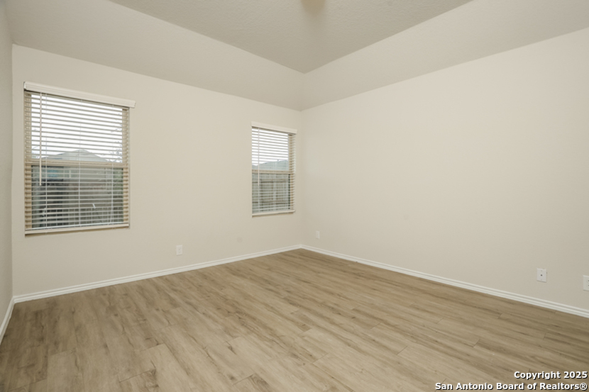 5227 Blue Ranch San Antonio, TX 78222 - Photo 9 of 17 an empty room with wooden floor and windows