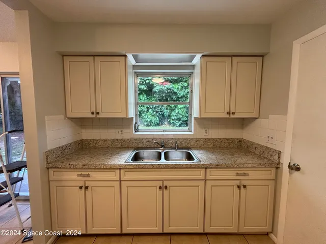a kitchen with granite countertop white cabinets and white appliances