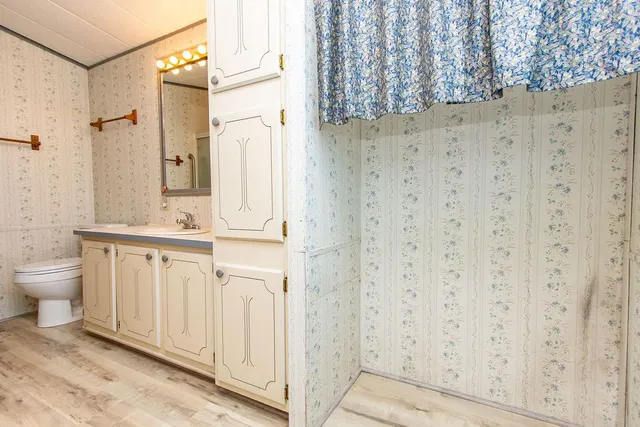 a bathroom with a granite countertop sink a toilet and a shower